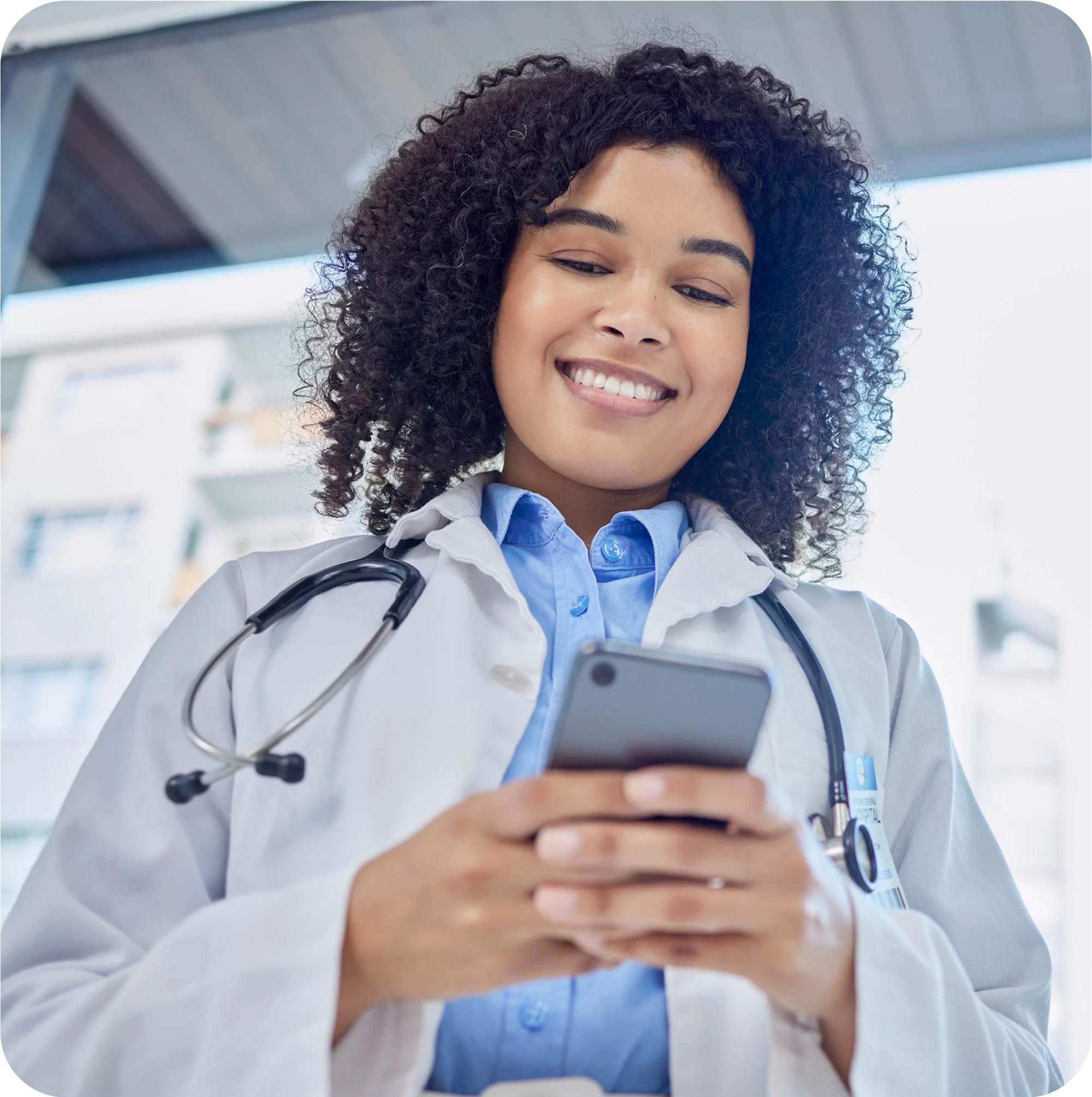 Smiling female doctor using a smartphone, representing mobile health technology.